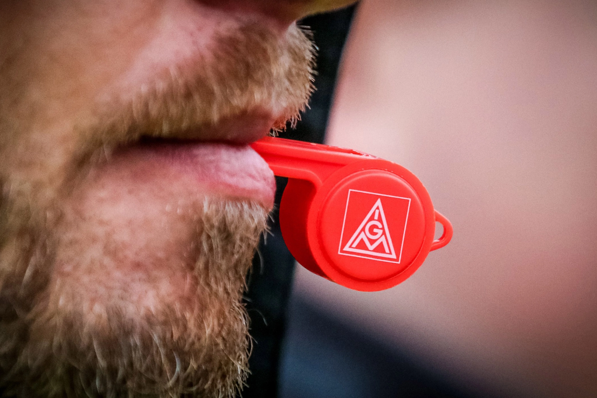 Nahaufnahme von einem bärtigen Mann mit Pfeife im Mund.